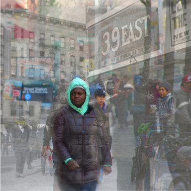 A bustling city street scene with blurred figures and vibrant storefronts.